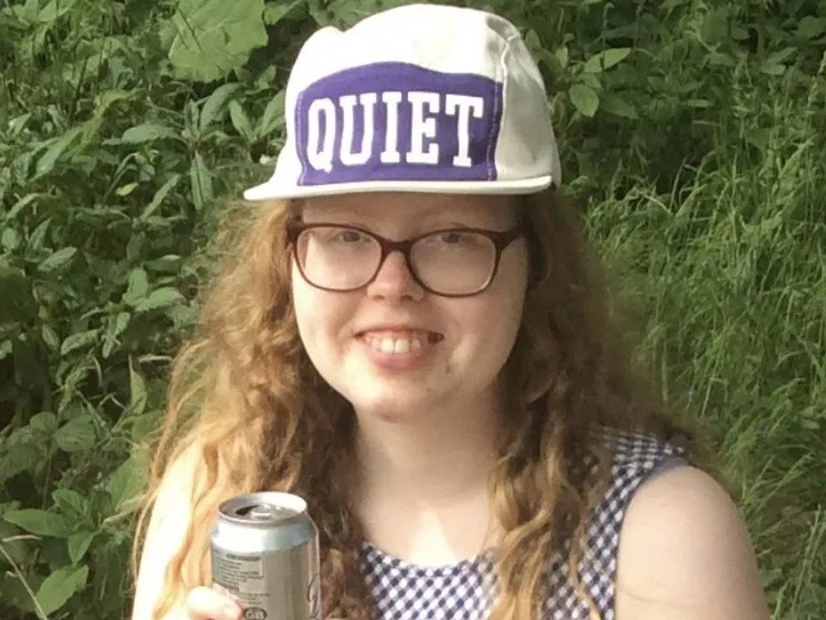 A young resident smiling in the garden, wearing a cap